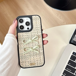 Detail of tweed texture phone case with bows and gold plate for iPhone 16 Pro Max