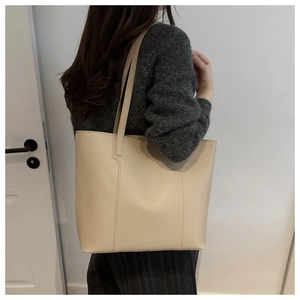 Detailed view of a beige tote bag showing high-quality texture and minimalist stitching