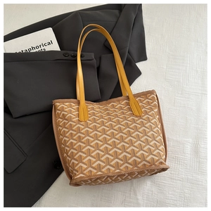 Macro shot of Goyardine pattern coated canvas on a yellow tote bag with brown leather trim