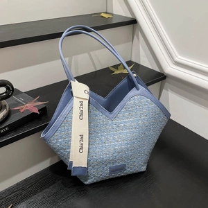 Blue tweed tote bag with gold glitter texture and leather trim on wooden stairs