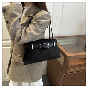 Detail of vintage black suede shoulder bag with wide belt buckle and silver hardware