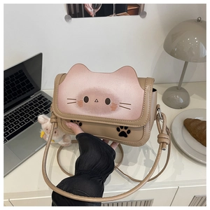 Close-up of cat-shaped crossbody bag with pink gradient flap and plush rabbit charm