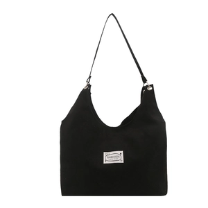 Minimalist black canvas tote bag with fashion bear patch on plain white background