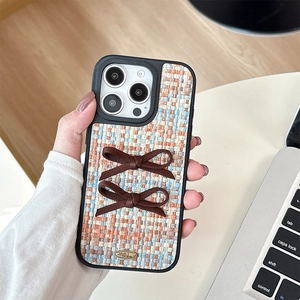 Detail of tweed iPhone case with two silk bows and golden engraved love metal plaque
