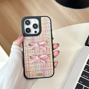Close-up of tweed iPhone case with pink bows and Love is Forever metal plaque