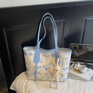 Stylish white tote bag with blue graffiti prints and a cute plush bunny pendant