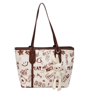 Contrast color tote bag with cartoon bear graffiti and white knit rabbit pendant