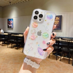 Detail of transparent phone case with glitter and starry planet patterns held by hand