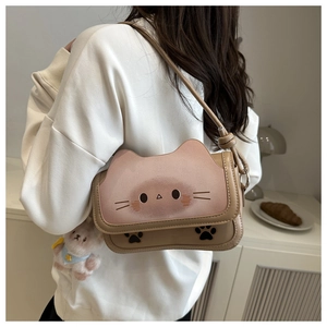 Détail d'un petit sac chat avec pendentif lapin en peluche porté par un mannequin