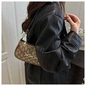 Dettaglio della borsa a spalla vintage con monogramma e catena in metallo a cuore