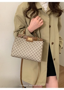 Classic monogram tote bag featuring vintage gold twist lock and brown leather handles