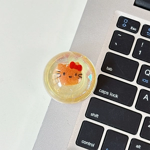 Detailed view of 3D Hello Kitty transparent resin phone griptok with glitter sequins