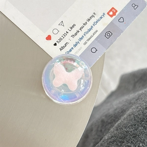 Macro detail of round phone socket featuring a 3D pink butterfly on pearl finish base
