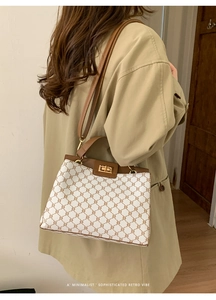 Detail of checkered canvas bag with leather trim and gold twist lock on model