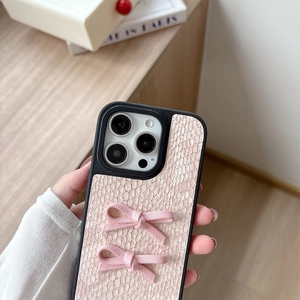 Detail of pink snakeskin texture phone case with 3D fabric bows for iPhone