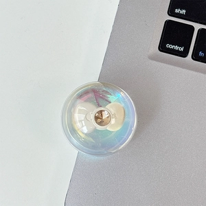 Macro shot of iridescent phone grip with white bow and sparkling gemstone detail