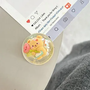 Close-up of a cute 3D yellow cartoon bear with heart inside a clear resin phone grip