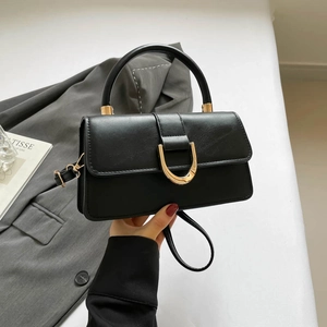 Klassische schwarze Handtasche mit goldener Schnalle und schmalem Schultergurt fürs Büro
