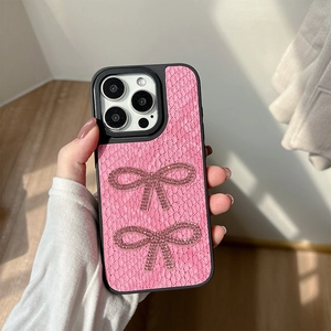 Dettaglio custodia iPhone rosa in pelle di coccodrillo sintetica con fiocchi di strass