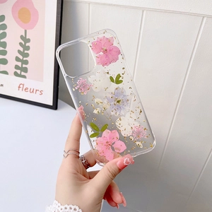Détail de la coque iPhone transparente avec fleurs séchées et feuilles d'or