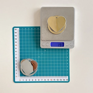 Macro view of heart-shaped mirror phone grips showing 5.5cm size and 19.7g weight