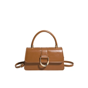 Minimalist caramel brown leather handbag with gold horse-bit buckle and top handle strap