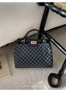 Close-up of retro printed handbag with gold metal clasp on minimalist ivory rug