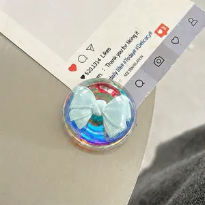 Macro shot of a transparent phone grip with a 3D light blue ribbon design and resin finish