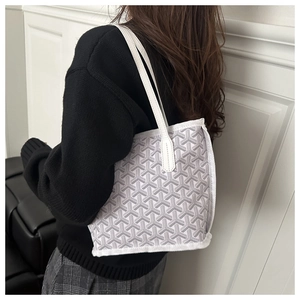 Detail showing the gray and white Y-pattern tote bag with elegant leather shoulder straps