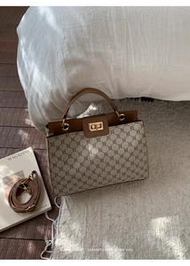 Detailed view of vintage monogram canvas and brown leather stitching on handbag