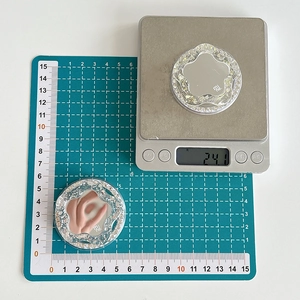 Detail shot of a glittery flower magnetic phone socket with mirror on a scale
