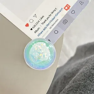 Macro shot of circular phone grip featuring green glitter sequins and smooth gradient finish