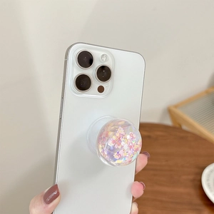 Close-up of hand holding a phone socket with dreamy glitter and floral sequins
