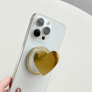Detail of a heart-shaped golden mirror MagSafe phone grip with a magnetic base