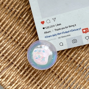 Macro view of a laser holographic heart phone grip with glitter resin on a rattan tray