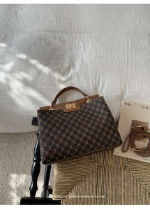 Close-up of vintage brown monogram tote bag with leather handles and metallic twist lock