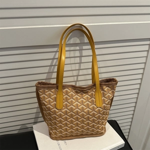 Yellow tote bag with classic Y-pattern and leather handles for stylish daily commuting