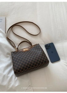 Detail of vintage monogram canvas handbag with leather handle and gold twist lock