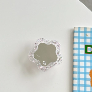 Macro view of flower-shaped phone grip with glitter acrylic edge and central mirror