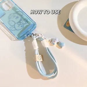 Blue thick woven phone lanyard wrist strap with star and cloud charms on case
