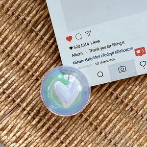 Macro shot of iridescent resin phone grip featuring a 3D purple heart and glitter finish