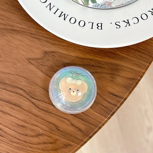 Macro detail of a 3D cute bear phone grip with iridescent glitter and a clear resin dome