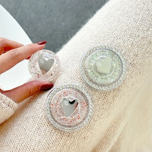 Sparkling rhinestone heart-shaped phone grip stand with silver 'mi ne.' lettering