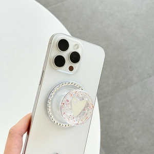 Close-up of white glitter heart phone grip with rhinestones and silver mi.ne. center