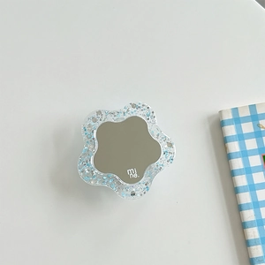Close-up of a floral rhinestone phone socket featuring blue glitter and a small mirror