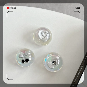 Detailed macro view of iridescent crystal heart, cherry, and bow phone grip accessories