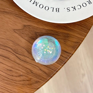 Macro shot of a laser crystal phone grip with heart and star glitter sequins on wood