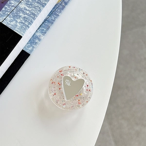 Close-up of heart-shaped glitter phone grip tok with mirror surface and mine text