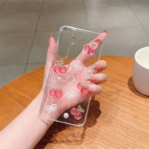Clear Samsung S25 case featuring 3D glitter cherry, pearl, and bow tie decorations