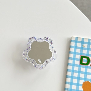 Close-up of a floral rhinestone phone socket with a mirror finish and glitter resin